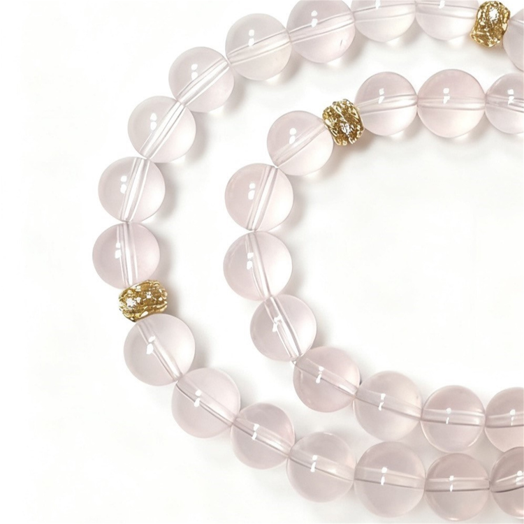 Close-up detail of rose quartz crystal bracelet showing pink translucent beads