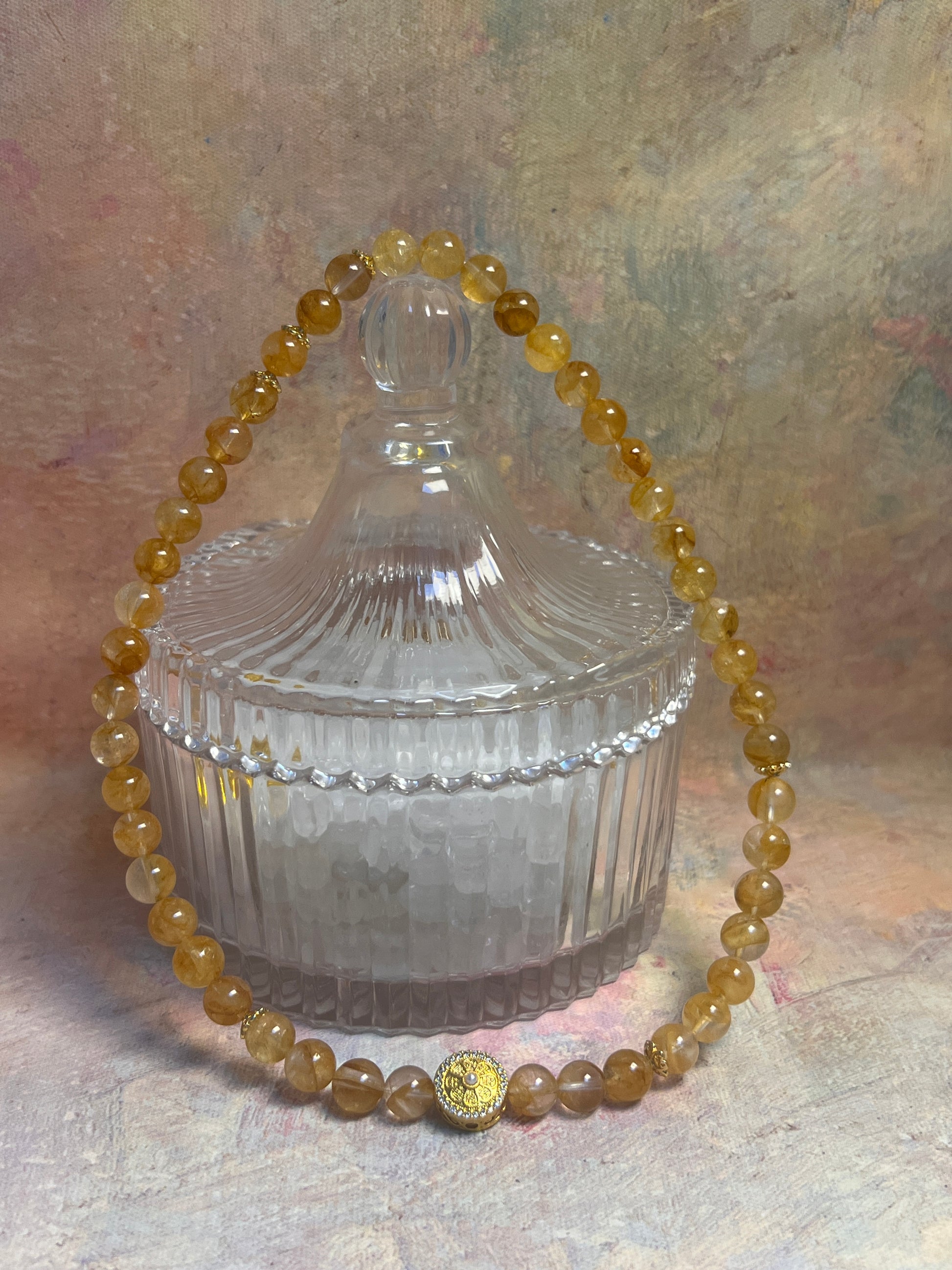 Beaded bracelet with a gold clasp on a textured surface